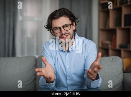 Confident young european male doctor psychologist gesturing with his hands in clinic interior, close up Stock Photo