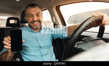 Happy driver using showing smartphone with empty screen Stock Photo