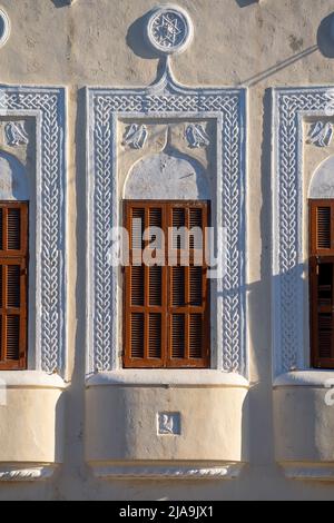 Wooden antique windows with arched shape on a painted old wall. Stock Photo