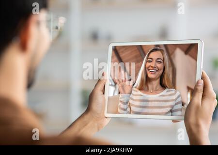 Unrecognizable young man holding digital tablet, having video conference Stock Photo