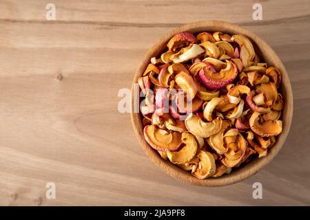 Bowl full of dried apples on a wooden background Stock Photo