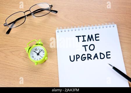 Close up of time to upgrade words on notepad Stock Photo