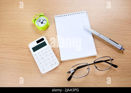 Alarm clock with empty notepad and pen on a wood desk Stock Photo