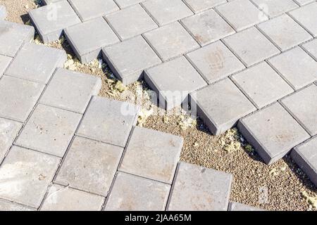 connection at an angle of two pedestrian paths paved with paving slabs, selective focus Stock Photo