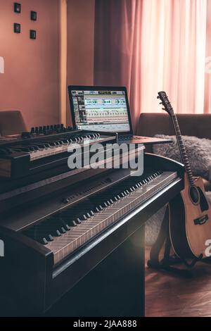 Electronic piano and guitar in room interior. Stock Photo