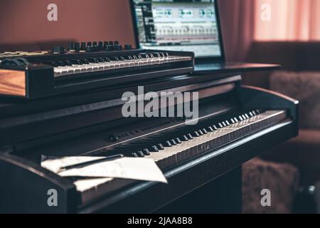 Electronic piano and guitar in room interior. Stock Photo