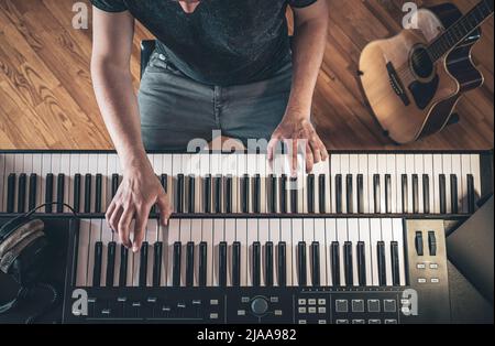 Male hands on the piano keys, top view. Stock Photo