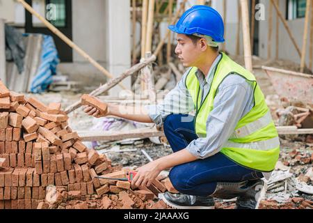 Engineer foreman manager quality check Burnt Clay Bricks for good construction building project Stock Photo