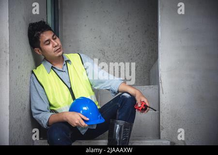 Tired exhausted and napping engineer builder worker in construction site Stock Photo