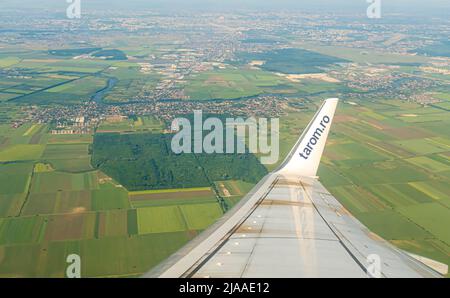 Flying over Romania, near Bucharest, Otopeni - aerial view with a wing from an airplane window seat, plane operated by Romanian air carrier Tarom Stock Photo