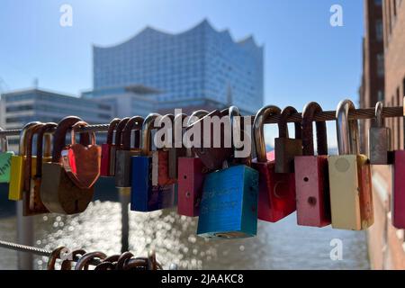HAMBURG, GERMANY - MARCH 27, 2022: Colorful Love Locks hanging on a bridge in the Speicherstadt and port of Hamburg. Concert Hall Elbphilharmonie out Stock Photo
