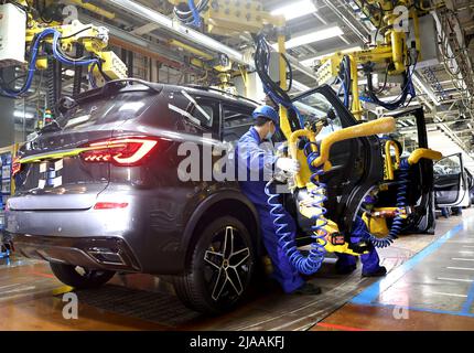 Shanghai, China. 23rd Apr, 2022. A man works at the assembly line of automaker SAIC Motor Company's Lingang base in Shanghai, east China, April 23, 2022. Credit: Chen Jianli/Xinhua/Alamy Live News Stock Photo