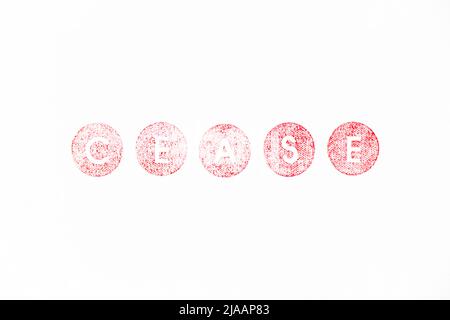 Red color rubber stamp in word cease on white paper background Stock Photo