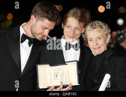 Cannes, France. 28th May, 2022. Director Lukas Dhont (L) and Eden Dambrine (C) for the film 'Close' pose with director Claire Denis for the film 'Stars at Noon' during a photocall after the two films won the Grand Prix at the closing ceremony of the 75th edition of the Cannes Film Festival in Cannes, southern France, May 28, 2022. Credit: Gao Jing/Xinhua/Alamy Live News Stock Photo