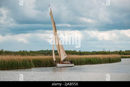 Horning, Norfolk, UK – May 28 2022. Traditional wooden river cruiser class sailing boat on the River Bure leg of the 2022 Three Rivers Race, an annual Stock Photo