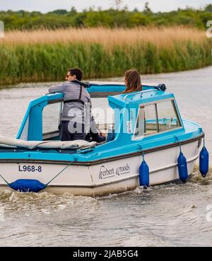 Horning, Norfolk, UK – May 28 2022. A Herbert Woods leisure day boat on the River Bure, Norfolk Broads on a dull, cloudy and overcast day Stock Photo