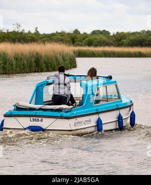 Horning, Norfolk, UK – May 28 2022. A Herbert Woods leisure day boat on the River Bure, Norfolk Broads on a dull, cloudy and overcast day Stock Photo