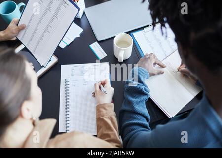 Top view at young black man taking notes during English seminar in office Stock Photo