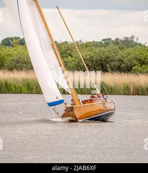 Horning, Norfolk, UK – May 28 2022. Traditional wooden river cruiser class sailing boat on the River Bure leg of the 2022 Three Rivers Race, an annual Stock Photo