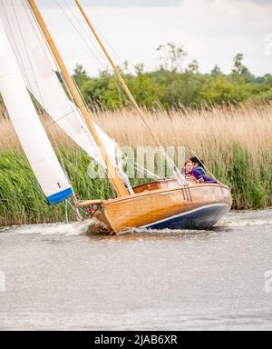 Horning, Norfolk, UK – May 28 2022. Traditional wooden river cruiser class sailing boat on the River Bure leg of the 2022 Three Rivers Race, an annual Stock Photo