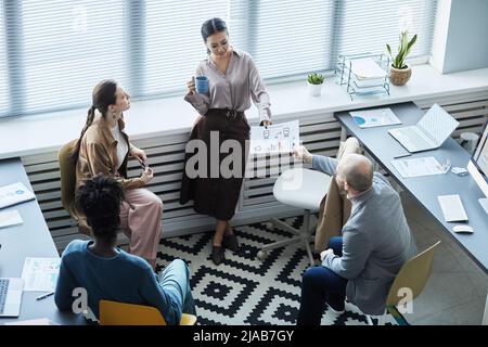 High angle view at diverse group of business people brainstorming project ideas while working together in office Stock Photo