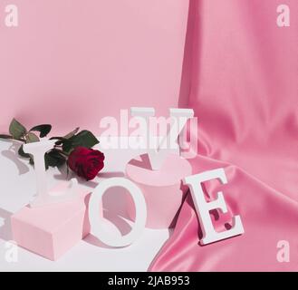 Pastel pink composition with satin curtain and palm leaf shadow ...