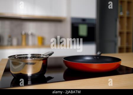 Empty frying pan and sauce pan on induction cooktop Stock Photo