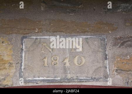 Close-up of the date stone above the front entrance door of an old circa 1840 Canadiana cottage style fieldstone home. Stock Photo