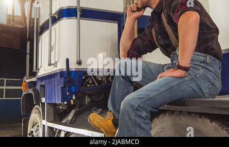 Relaxed Caucasian Truck Driver Seating on the Ground and Support His Back  on the Semi Truck Wheel Stock Photo - Alamy