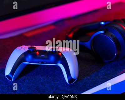 Close-up. Video game accessories - gamepad and headphones. Modern equipment, dartless technologies, electronics. Video games, mobile games. Passion, h Stock Photo