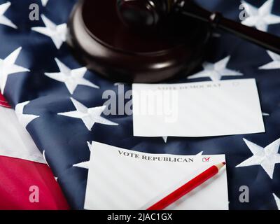 Close up of ballots and USA flag on table in voting station, copy space ...