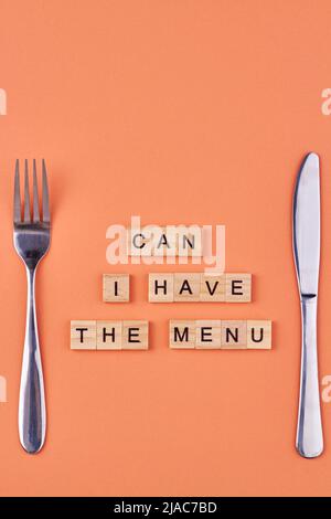 Wooden cubes with the inscription Can I have the menu and cutlery. Flat lay composition on color background. Stock Photo