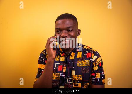 Young smiling black guy in photo studio on phone amused with girlfriend. Stock Photo