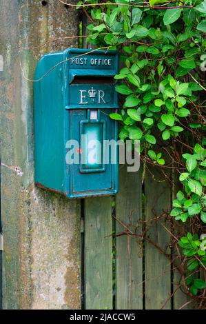 An Irish style post box hanging on a garden fence in the hamlet of Beal, Northumberland, UK Stock Photo