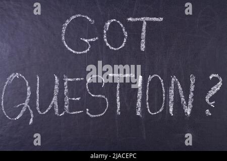 Got question handwritten inscription with white chalk on black chalkboard. Meaning do you have any questions. Stock Photo