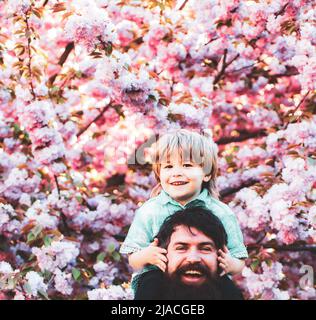 Father and son. Father With Son Having Fun In Park. Dad and son playing together outdoors. Stock Photo