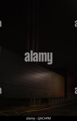 Factory / Warehouse in an ominous night setting, located in Manchester International Airport, Greater Manchester, United Kingdom. Stock Photo