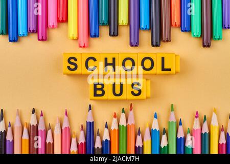 Flat lay composition with school bus inscription written on yellow cubes. Top view. Stock Photo