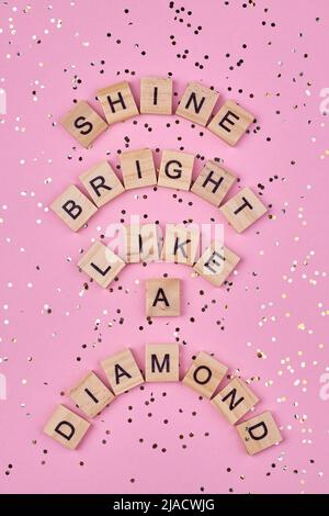 Text shine bright like a diamond written on wooden blocks. Top view and flat lay. Stock Photo