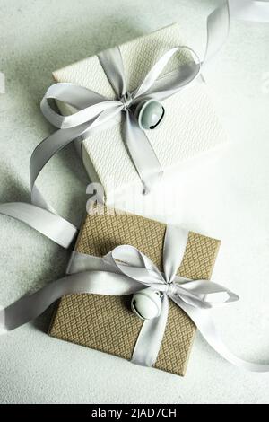 Two gift boxes on a table wrapped with ribbons and bells Stock Photo