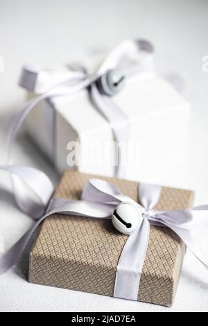 Two gift boxes on a table wrapped with ribbons and bells Stock Photo