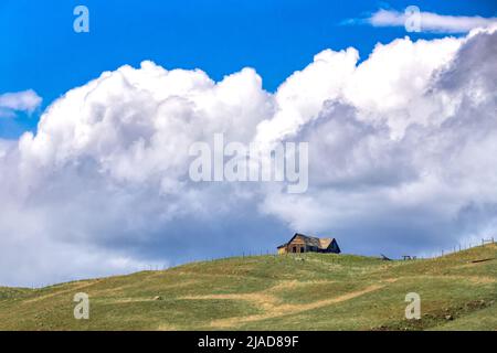 Molson, WA - USA: 05-10-2022: An old log cabin on top or the hill overlooks town Stock Photo