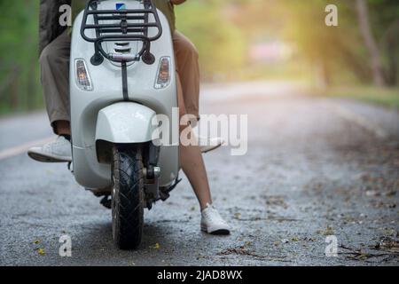 Close-up front view of a couple sitting on a scooter Stock Photo