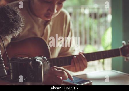 Close-Up of a man filming himself playing the guitar Stock Photo