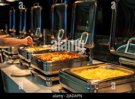 Buffet heated trays ready for service with pasta choice for breakfast Stock Photo