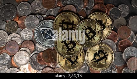 Piled up money coins, US Dollar coins, Penny, Dime and Quarter with Gold Bitcoin coins on top. Crypto and Dollar background Stock Photo