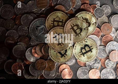 Piled up money coins, US Dollar coins, Penny, Dime and Quarter with Gold Bitcoin coins on top. Crypto and Dollar background Stock Photo