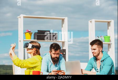 VR, technology and business concept. Team of three professional male and female designers wearing vr headsets, working with new virtual project in Stock Photo