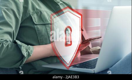 Woman using laptop and smartphone. Concept of online safety Stock Photo