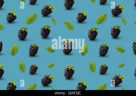 Many ripe blackberries and mint leaves on blue background. Pattern for design Stock Photo